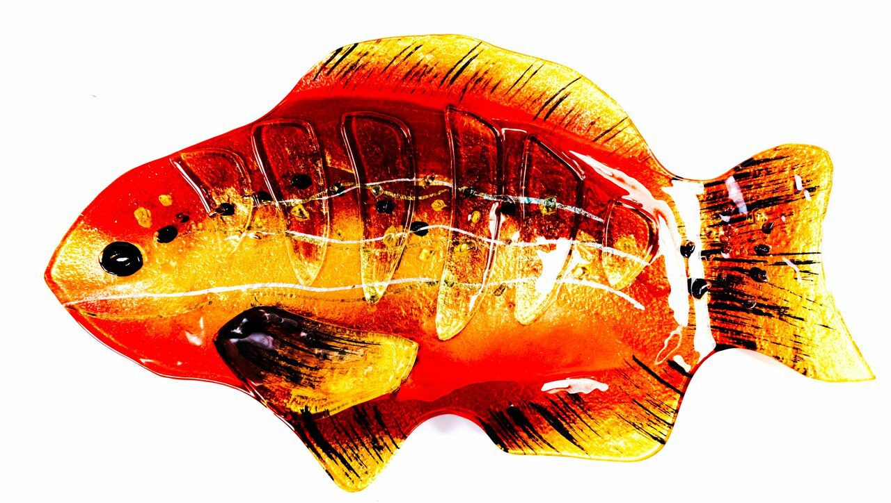 View from above the decorative fused glass fish plate. The reds, yellows, and oranges; translucent and vibrant, add to the visual appeal of any poisson - grille ou frit ou cuit - and any occasion; a social meal or a solitary culinary experience.