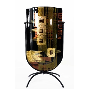Face of this powerful, mini-vase. Made of fused glass and featuring a versatile but strong color palette and design, this piece can accommodate a variety of interiors, though more masculine, dark colors, black, and darker hardwoods are among the more natural fits for this piece.